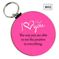 Pink round keychain with heart icon and motivational quote text