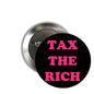 Tax the Rich round pinback button, black with pink “TAX THE RICH” text, metal back