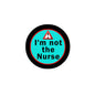 Circular pinback badge with black rim, aqua center, red warning triangle, and “I’m not the Nurse”