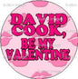 Round pink pinback button with purple text "BE MY VALENTINE"
