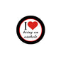 Pinback button badge with black rim, red heart, and text “I love being an asshole”