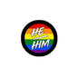 Round badge pin with rainbow background and “HE/HIM” lettering