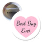 Round button pinback with pink heart and script text 'Best Day Ever', silver rim