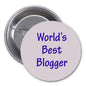 2.25-inch round pinback badge with blue 'World's Best Blogger' lettering and metal back