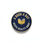 Round blue enamel pinback button with gold edge and open-book “A book a day” text