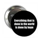 Round black pinback brooch with white quote: Everything that is done by hope