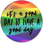 Round rainbow pinback button with black cursive quote text and purple bottom