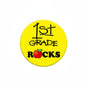 Yellow 2.25-inch pinback badge reading “1st GRADE ROCKS” with apple and leaves