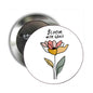 Round pinback brooch with colorful flower illustration and Bloom with Grace text