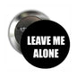 Round black button pinback brooch with white “LEAVE ME ALONE” text and metal clasp