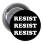 Black pinback button with stacked white “RESIST” text