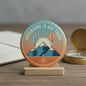 2.25-inch round pinback button: teal hot air balloons over mountains and compass.