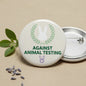 White round pinback button with green anti–animal testing text, rabbit icon, metal pin