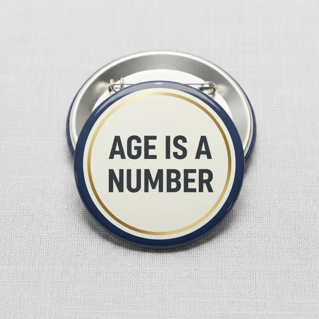 2.25-inch pinback button with beige center, navy rim, and 'AGE IS A NUMBER' text