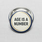 2.25-inch pinback button with beige center, navy rim, and 'AGE IS A NUMBER' text