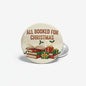 Round cream pinback button with 'ALL BOOKED FOR CHRISTMAS' text, books and gift icons