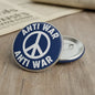 Circular anti-war pin badge with peace symbol and blue-and-white lettering