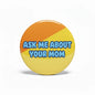 Round pinback button with orange and yellow halves and blue text: “ASK ME ABOUT YOUR MOM”