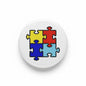 Circular Autism Awareness pinback button with colorful puzzle pieces, black border