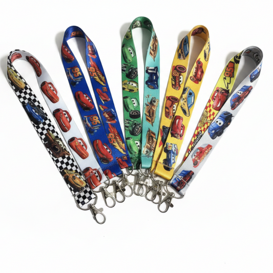 Five colorful lanyards with metal clip attachments, featuring various Cars-themed character prints on white, blue, green, yellow, and black-and-white checkered backgrounds.