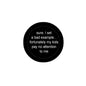 Round black pinback button with white quote text: 'pay no attention to me'