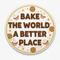 2.25-inch pinback button with 'BAKE THE WORLD A BETTER PLACE' and cookie icons