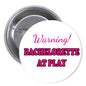 Round pinback button reading 'Warning! Bachelorette at Play' on white