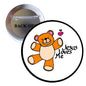 Pinback button with orange teddy bear holding hearts and text “Jesus Loves Me”