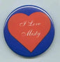Blue pinback button with orange heart and white script text