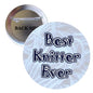 Round pinback button with text “Best Knitter Ever” on white fabric-look background