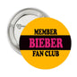 Round 2.25-inch pin-back button with metal rim; yellow and black Bieber fan club graphic.