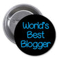 Black pinback badge with blue text reading "World's Best Blogger"