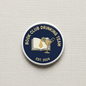 Round navy enamel pinback with gold book and cocktail graphic, “Est. 2024” text