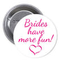 Round pinback button, white face with pink 'Brides have more fun!' and heart, metal back
