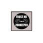 2.25-inch pinback button: black circle "TRUST ME I AM A ZOOKEEPER" with hands