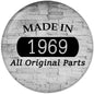 Round gray pinback badge with "MADE IN" and large "1969" text.