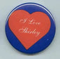 Heart-shaped pinback button with blue border and red heart reading “I Love Shirley”