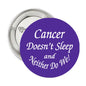 Purple round pinback button with “Cancer Doesn't Sleep” and “Neither Do We” text, 2.25-inch