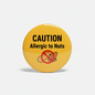 Yellow pinback button: 'CAUTION Allergic to Nuts' with crossed nut icon