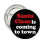 Round black pinback button with "Santa Claus is coming to town" text in red and white