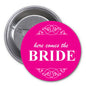 Pink pinback button with “Here Comes the BRIDE” text and floral heart design