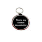 2.25-inch round keychain, black center, red rim, “You're my common denominator”