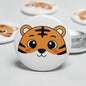 Round tiger cartoon face pinback button with orange-brown fur and black stripes