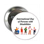 Round pinback button with International Day of Persons with Disabilities text and diverse figures