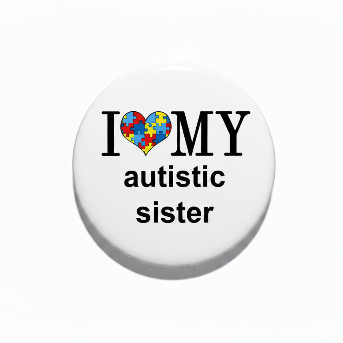 Pin-back badge, white circle with black rim, puzzle-heart I ♥ MY autistic sister text