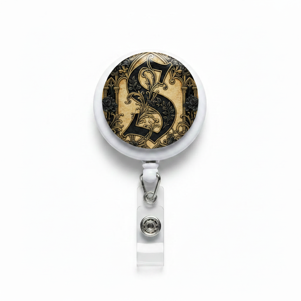 Round retractable badge reel with ornate gold and black medallion face