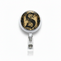 Round retractable badge reel with ornate gold and black medallion face