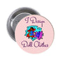 Round pinback badge with cartoon doll and “I Design Doll Clothes” text