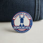 Round Democrats badge with blue donkey and “Progress & Unity” text