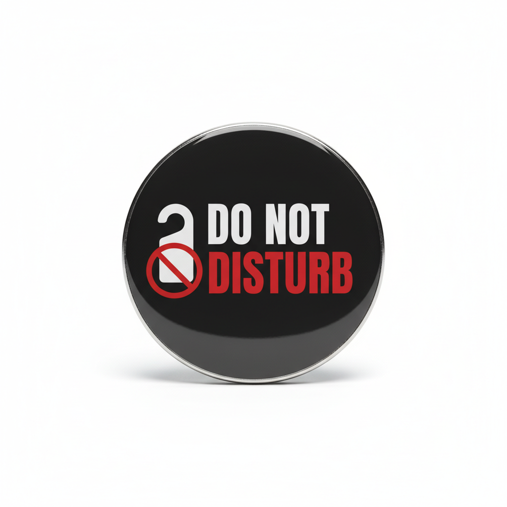 A round black pinback button with a silver metal rim, featuring the text 'DO NOT DISTURB' in white and red, alongside a white open lock icon with a red prohibition symbol, shown on a white background.